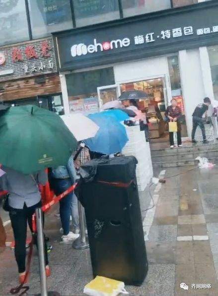 齐齐哈尔北方新天地门前排长队，自带马扎雨伞，大雨浇不散！