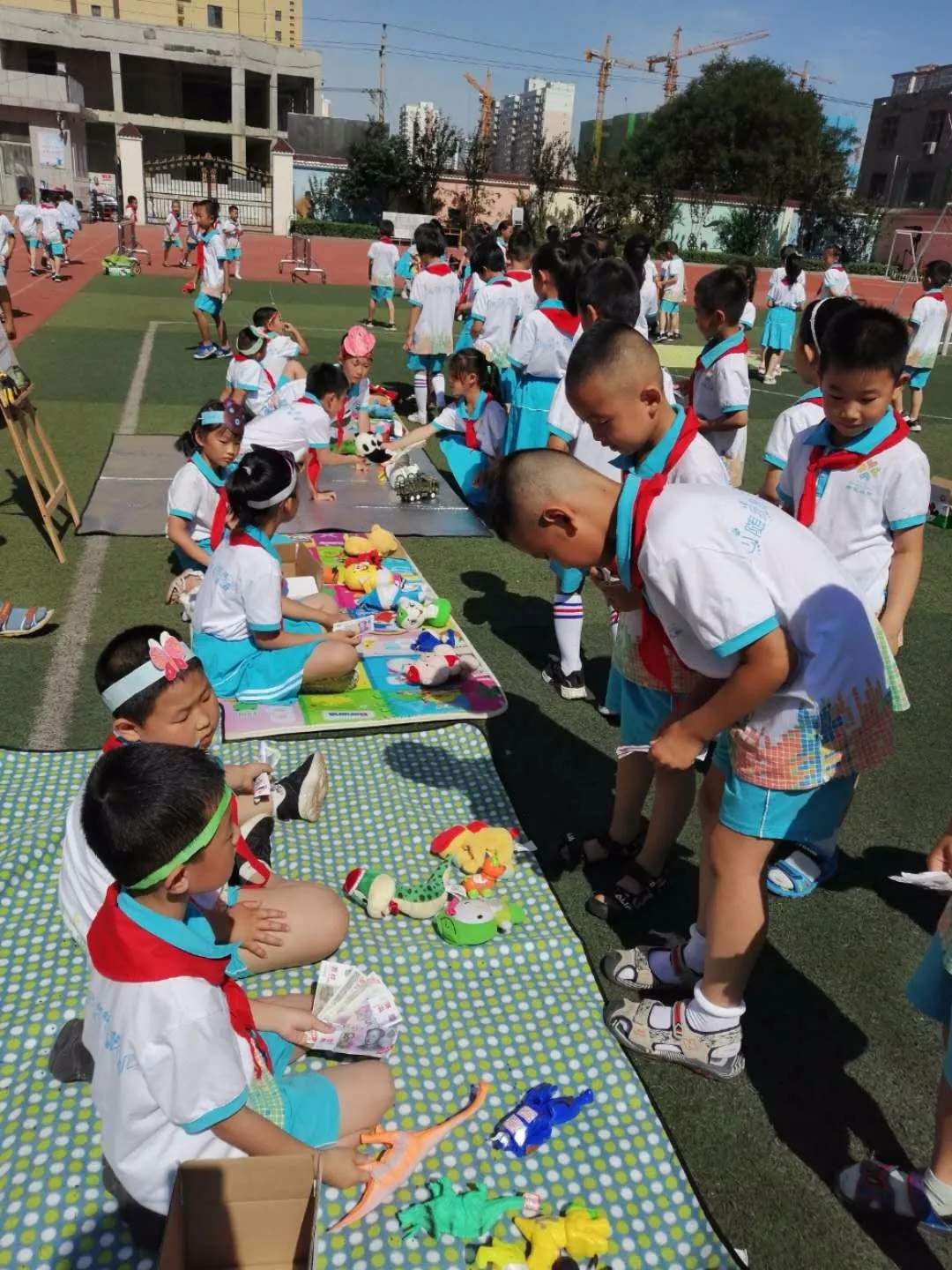 衡水新苑小学一年级的同学们在学校草坪举办跳蚤市场活动