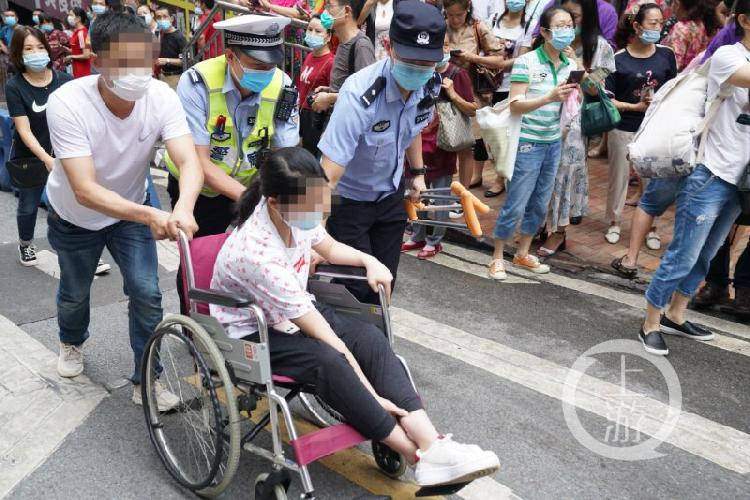 民警和保安护送轮椅考生进考场