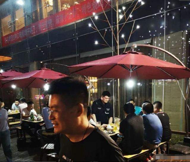 姚明深夜吃大排档，身材高大啤酒肚明显，与好友一杯接一杯